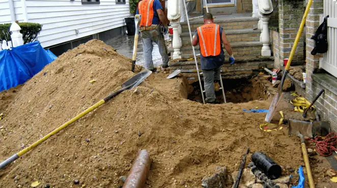 Contractors performing foundation protection and exterior drainage excavation near residential home steps in Sacramento, CA